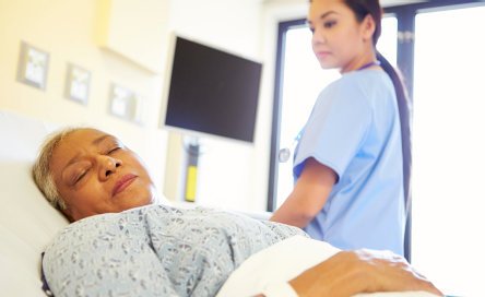 sleeping senior woman with female nurse